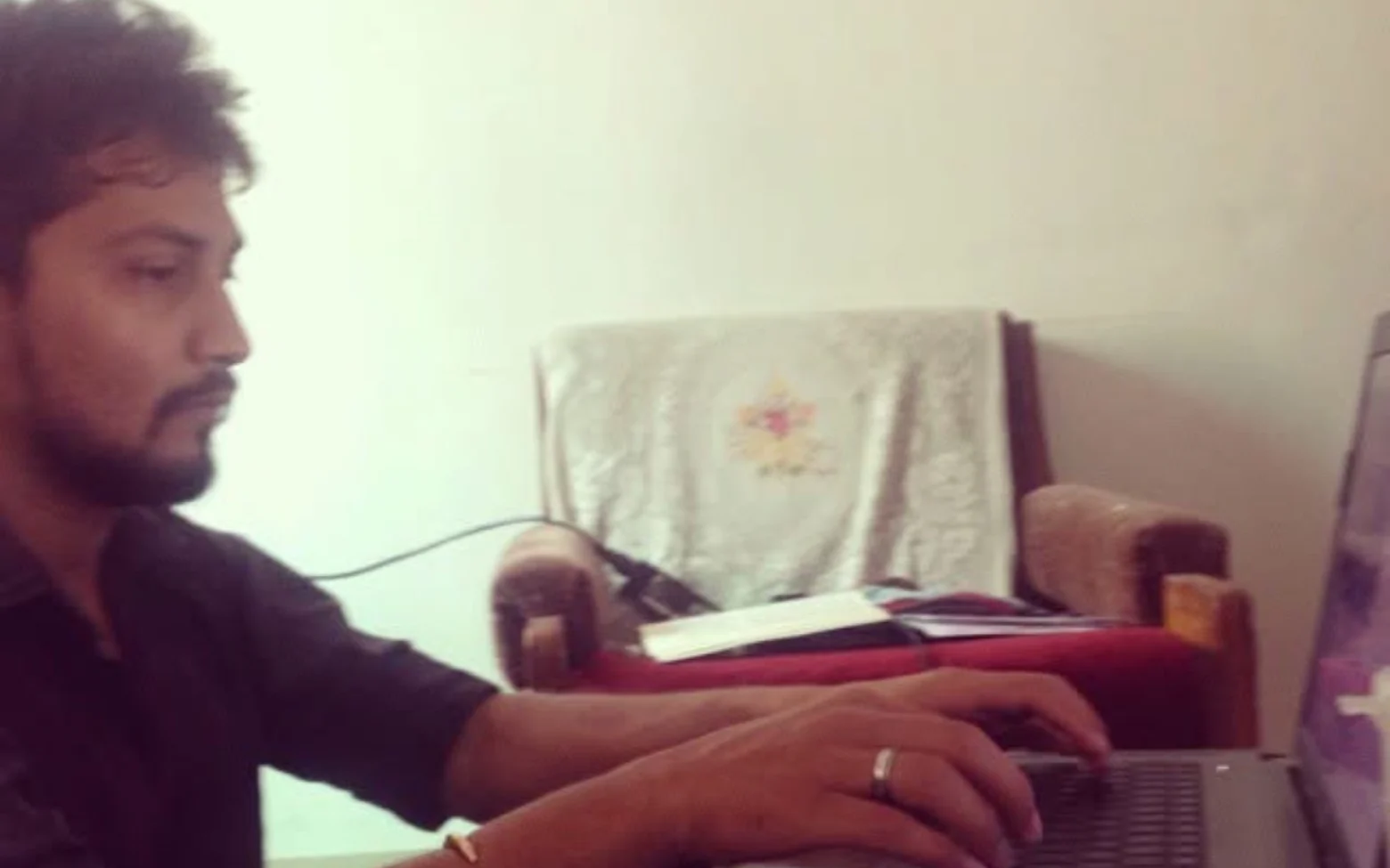 Digital Pratik smiling while working at his laptop