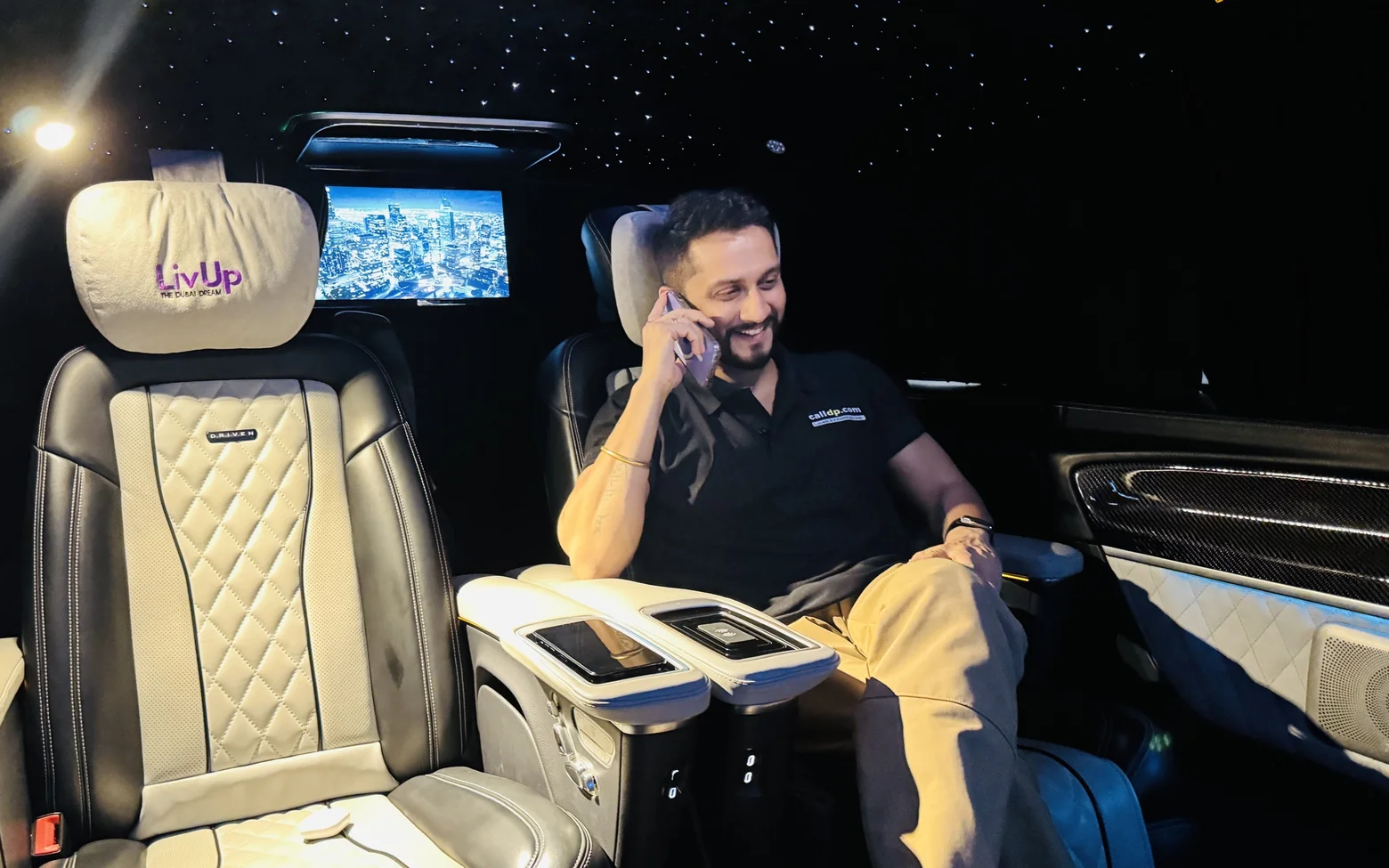 Digital Pratik laughing on a phone call in the back seat of a car at night