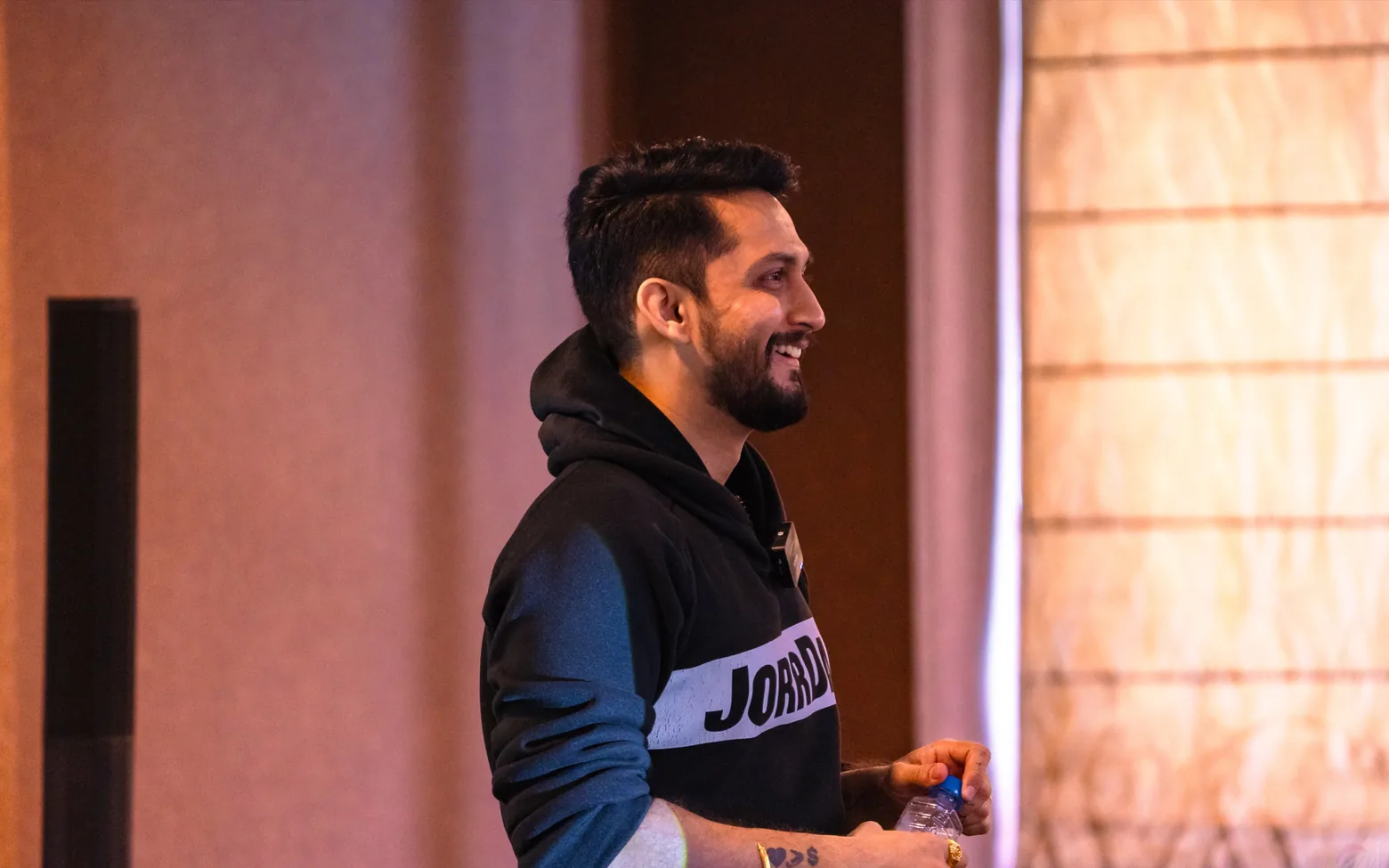 Digital Pratik smiling on stage in a black JorrDaar hoodie