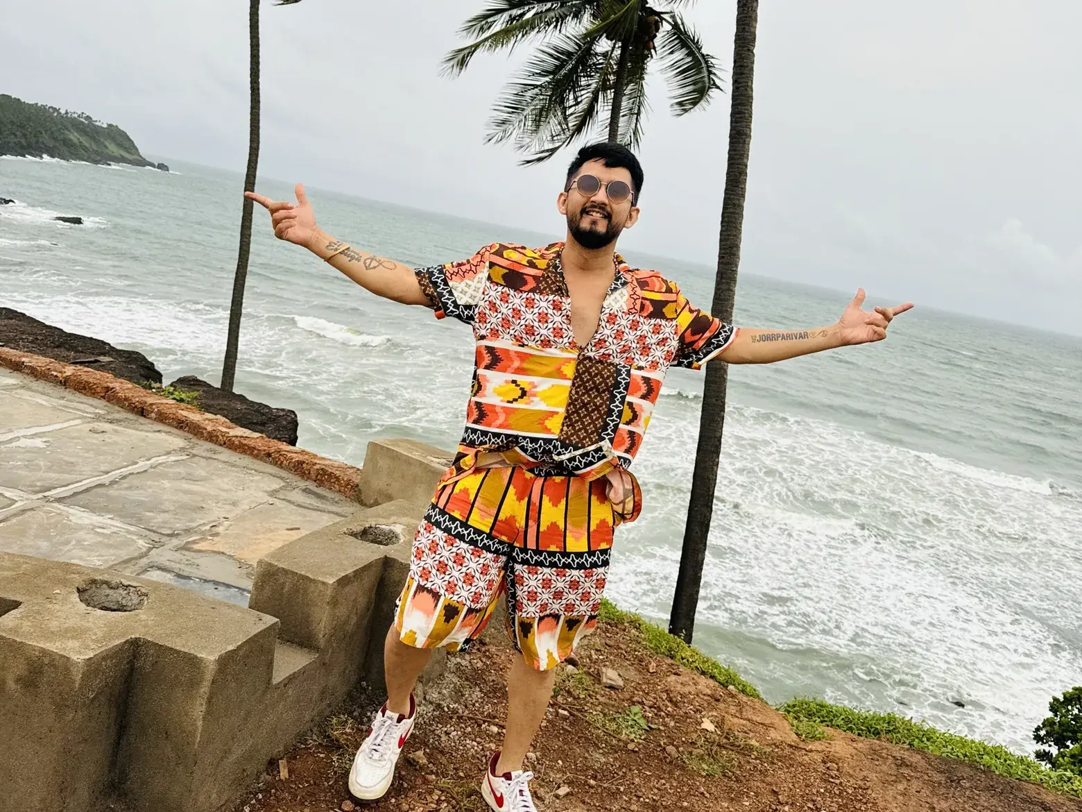 Digital Pratik laughing with his arms open on a cliff by the sea