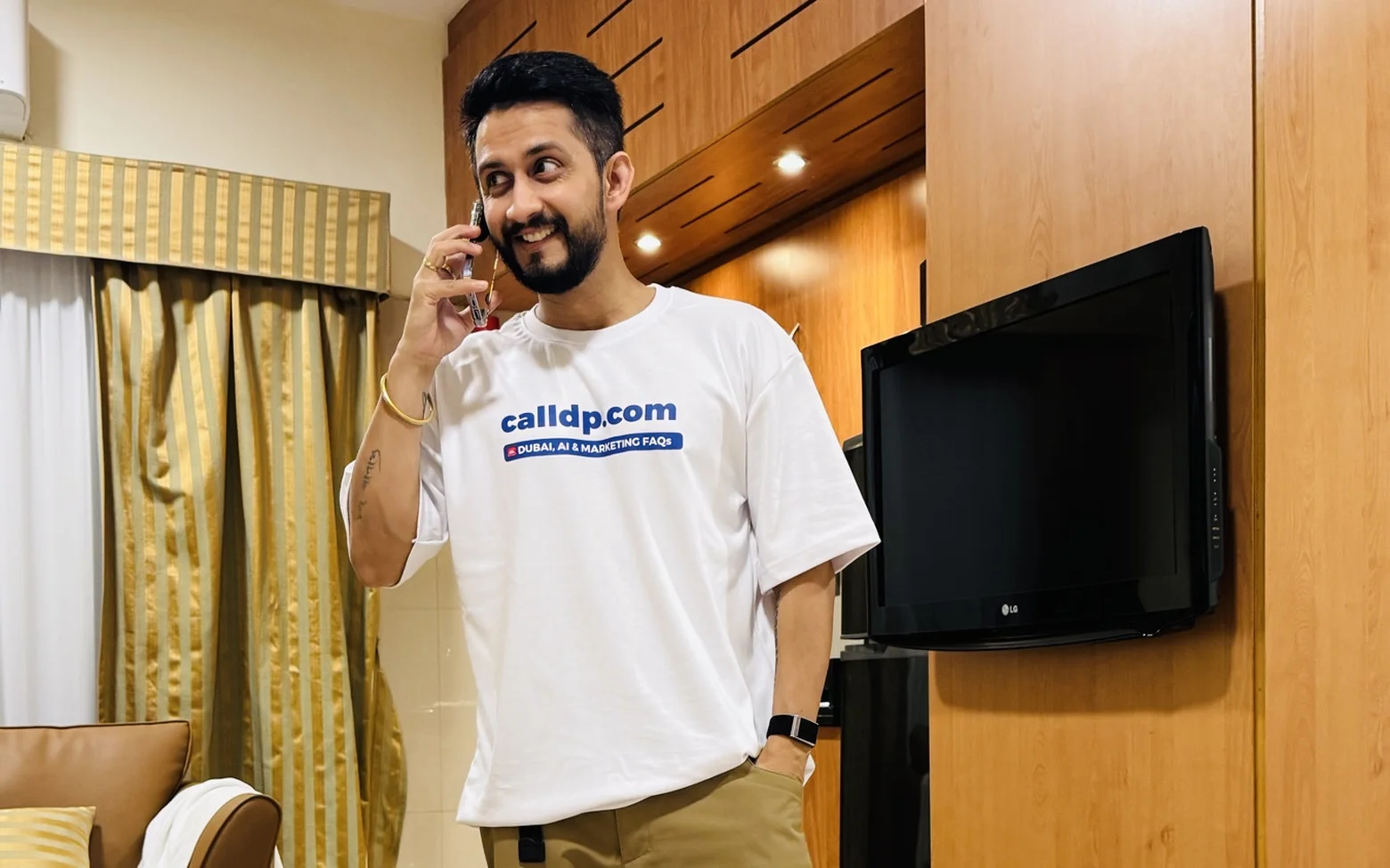 Digital Pratik smiling on a phone call at home in a white t-shirt