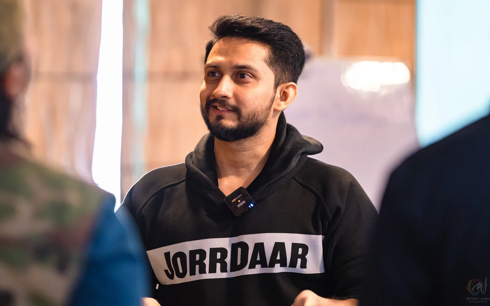 Digital Pratik smiling as he listens to someone in a workshop room