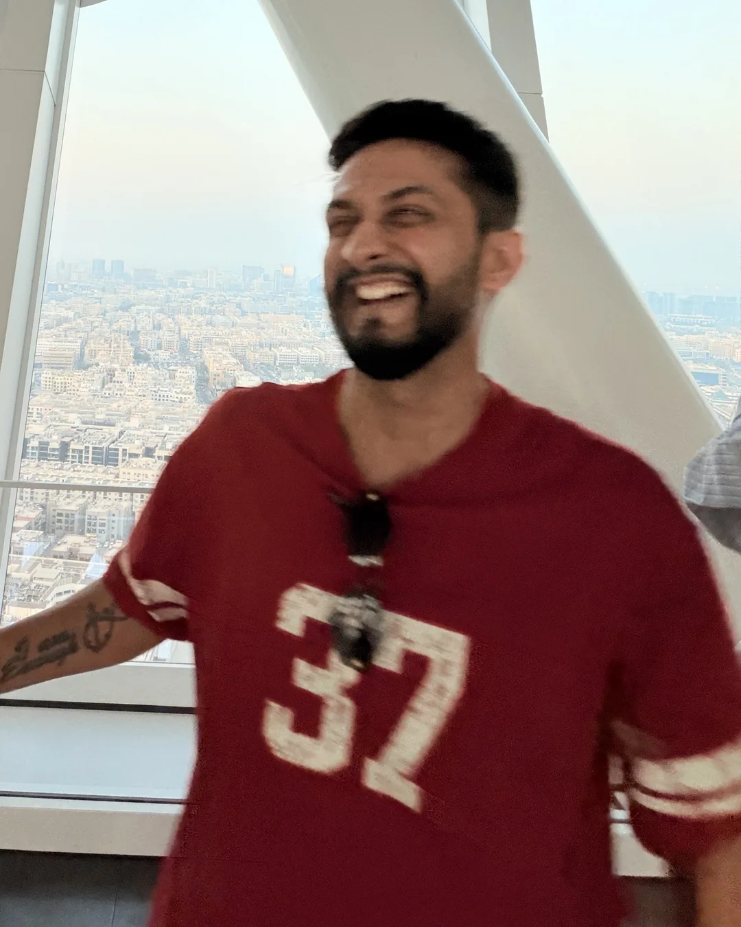 Digital Pratik laughing inside the Dubai Frame, the city far below